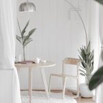 white steel chair in front round table on white rug